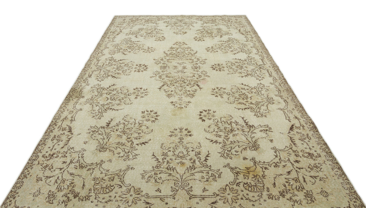 Cream and beige vintage-style rug with a distressed floral medallion pattern on a white background.