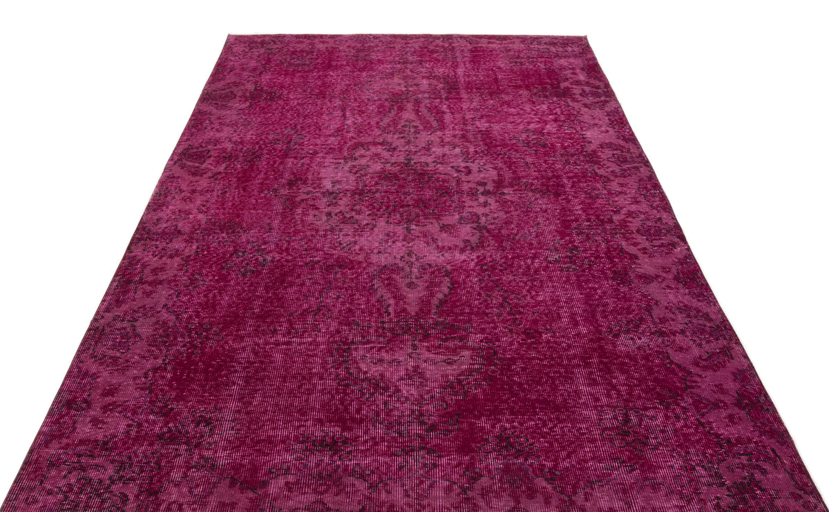 Magenta distressed vintage-style rug with a dark, faded traditional medallion pattern on a white background.