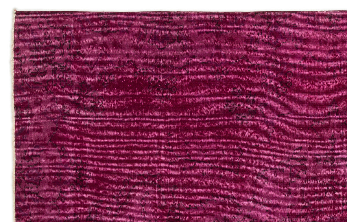Magenta distressed rug with a faded traditional floral medallion pattern on a white background.