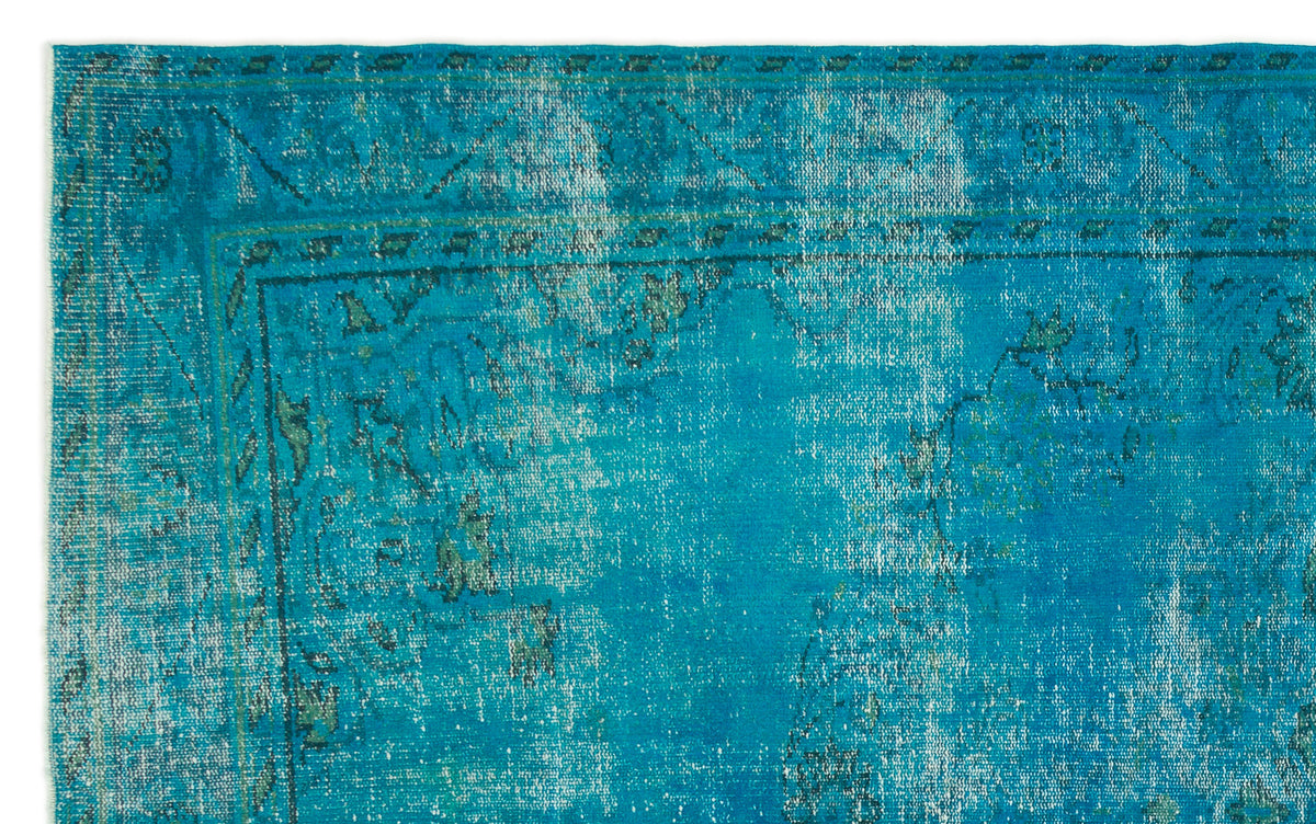 Bright turquoise distressed rug with a faded traditional border and central medallion pattern.