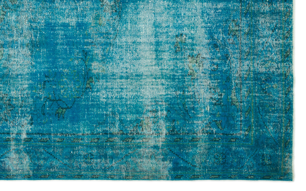 Teal and blue distressed rug with a faded traditional floral medallion pattern on a white background.
