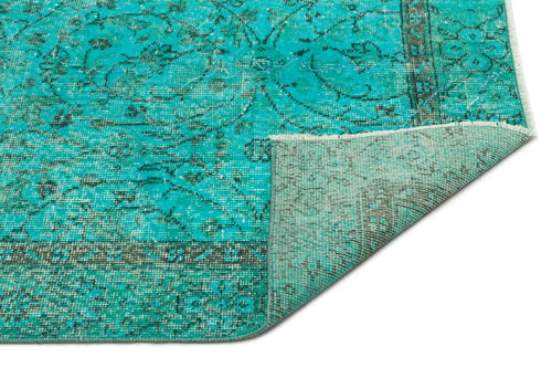 Load image 1 in gallery view. Turquoise and charcoal distressed rug with a traditional floral medallion pattern, shown with a corner folded over.