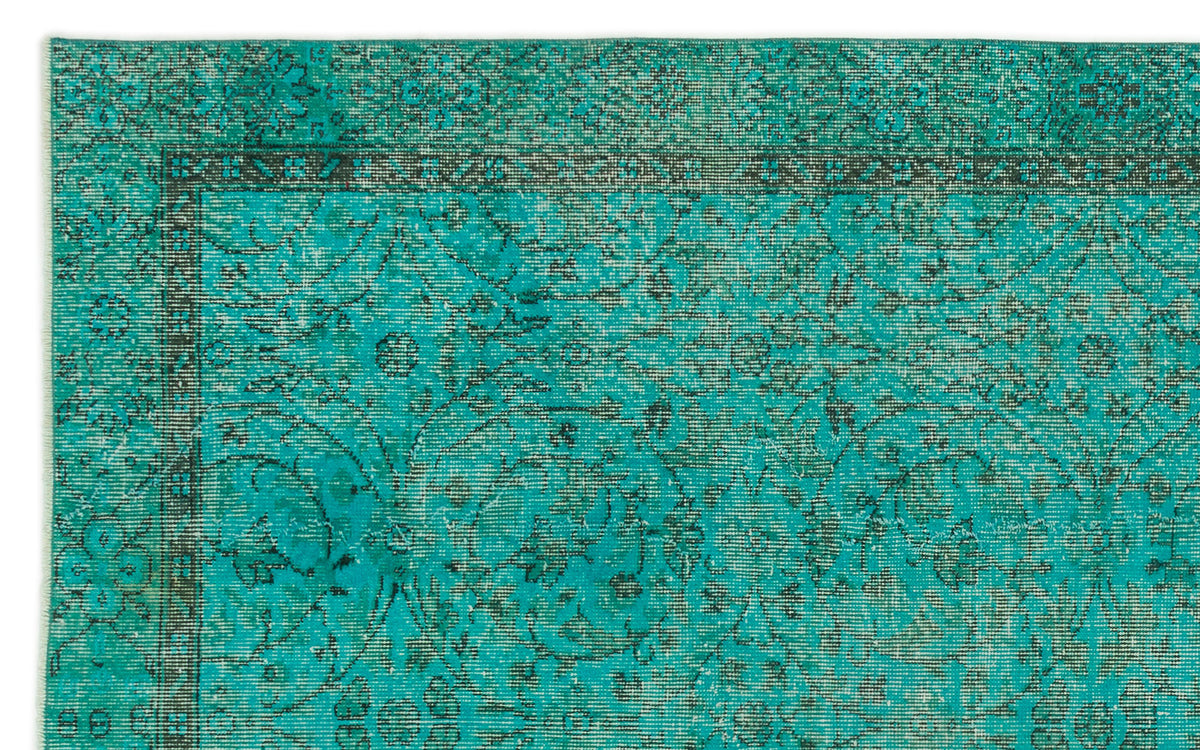 Teal and black distressed rug with a traditional floral medallion pattern and a detailed border.