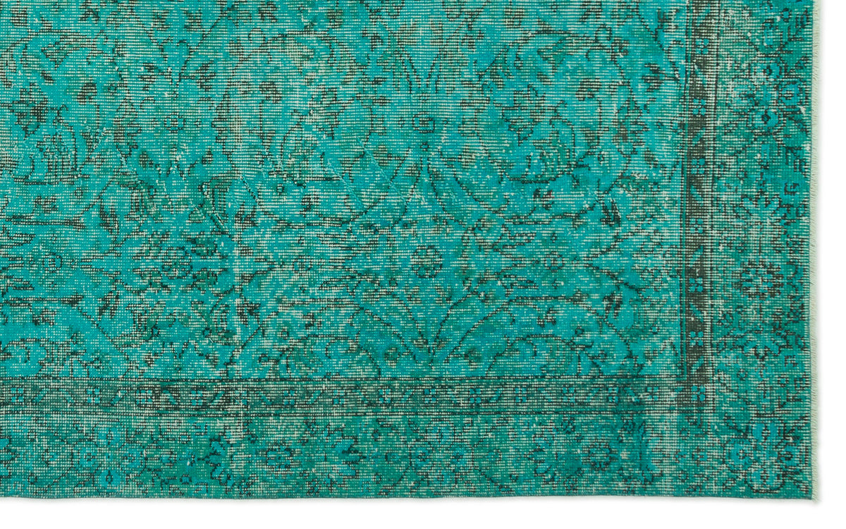 Teal and black distressed rug with a traditional floral medallion pattern and a bordered edge.