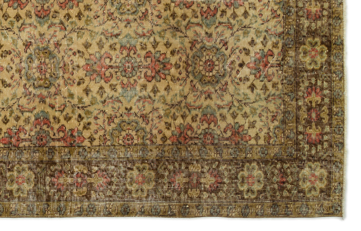 Tan traditional rug with a faded floral medallion pattern, intricate red and blue accents, and a dark brown border.