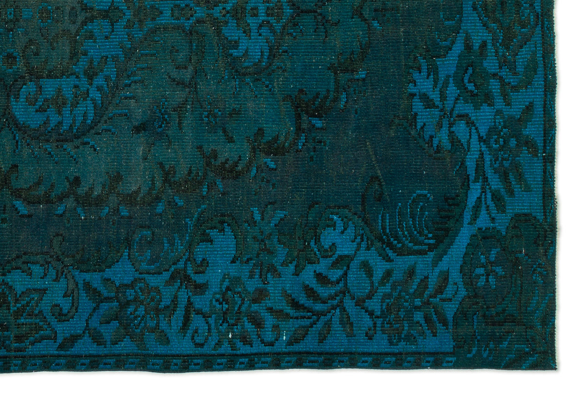 Teal and black rug with a detailed floral medallion pattern and a decorative border.