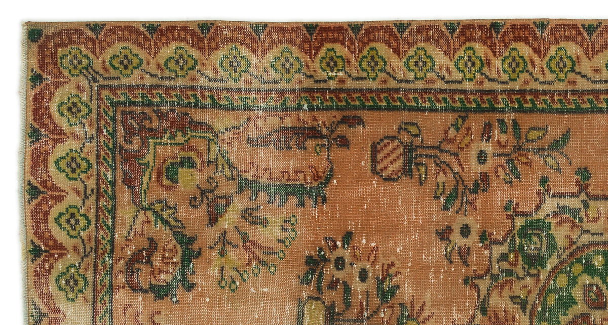 Distressed terracotta rug with a green and rust floral border and traditional botanical motifs on a white background.