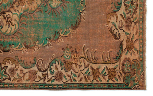 Load image 1 in gallery view. Distressed brown and green rug with a traditional floral medallion pattern and a decorative border.