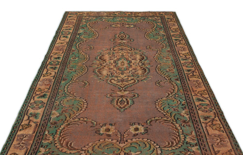 Load image 1 in gallery view. Distressed mauve, green, and tan vintage-style rug with a central floral medallion and ornate border on a white background.