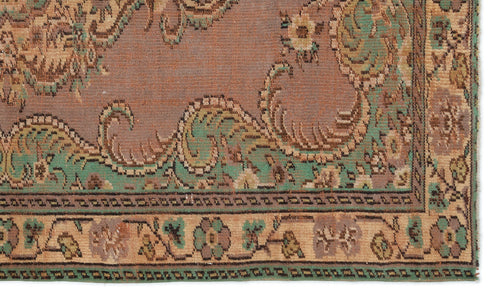 Load image 1 in gallery view. Mauve, green, and beige traditional rug with a distressed floral medallion pattern and a geometric border.