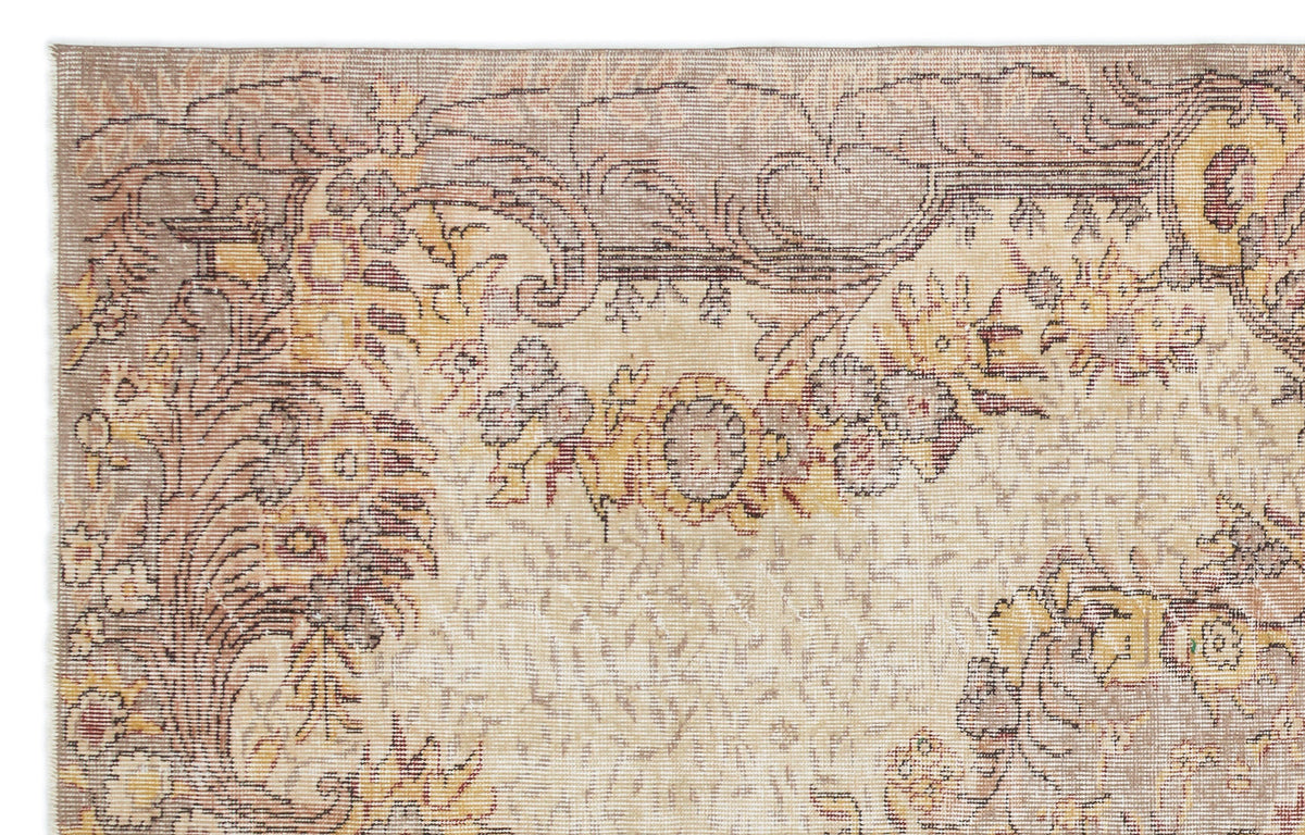 Beige and taupe traditional rug with a distressed floral medallion pattern and yellow accents.