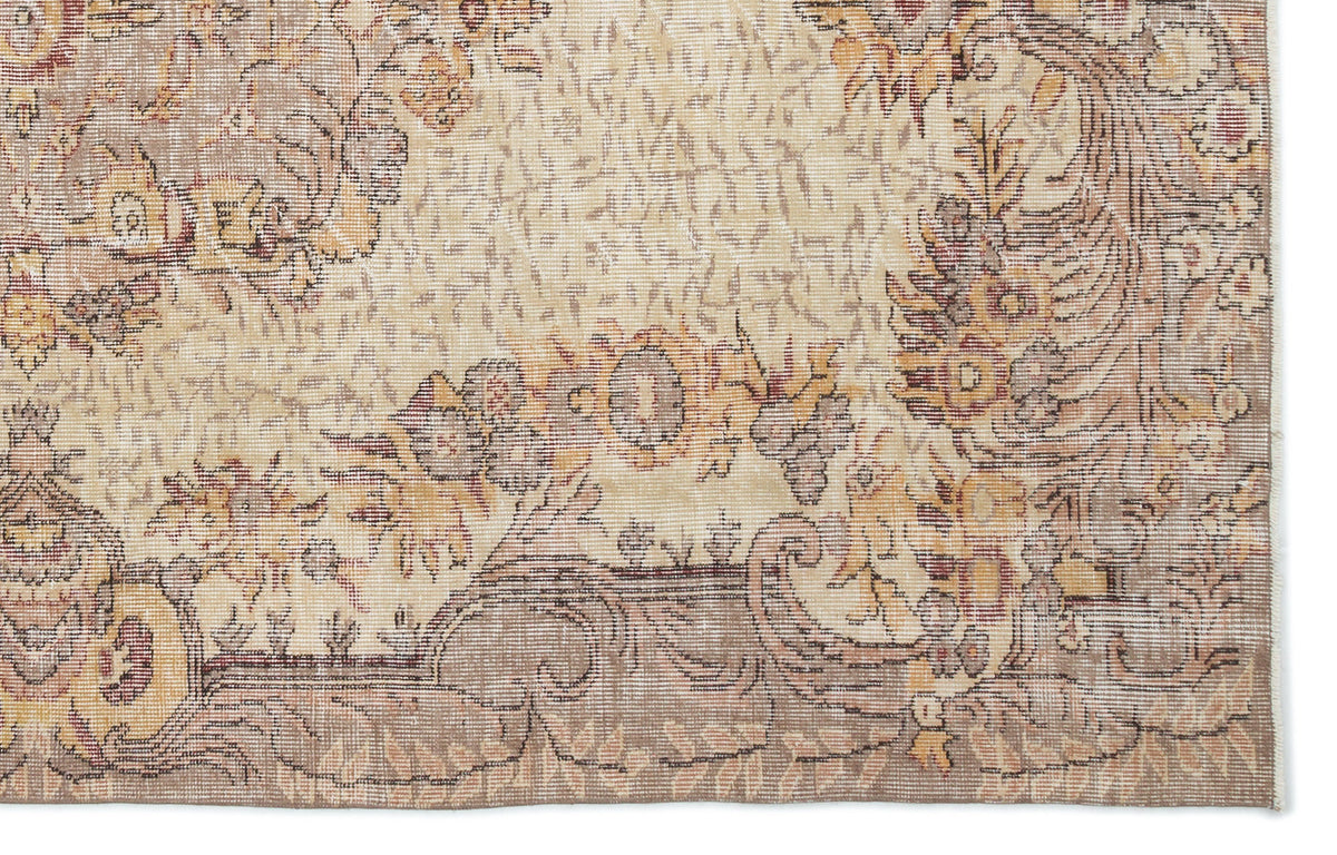 Beige and taupe traditional rug with a distressed floral medallion pattern on a white background.