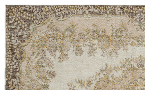 Load image 1 in gallery view. Distressed beige rug with a dark brown border and faded floral medallion pattern in olive green and mustard yellow.