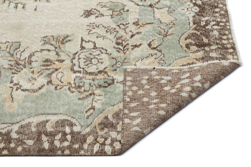 Load image 1 in gallery view. Distressed sage green and brown floral medallion rug on a white background with a folded corner showing the backing.