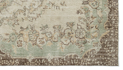 Load image 1 in gallery view. Distressed beige, sage green, and brown rug with a traditional floral medallion pattern and ornate border.