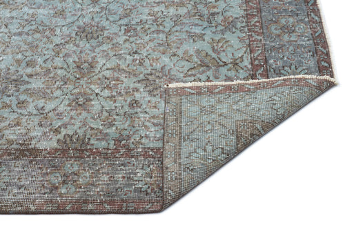 Load image 1 in gallery view. Distressed blue and brown traditional floral rug with a folded corner revealing the underside on a white background.