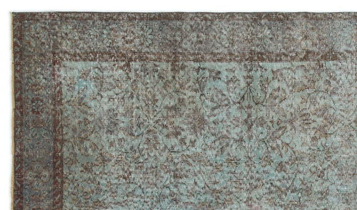 Load image 1 in gallery view. Distressed teal and brown rug with a traditional floral medallion border and intricate vine pattern.