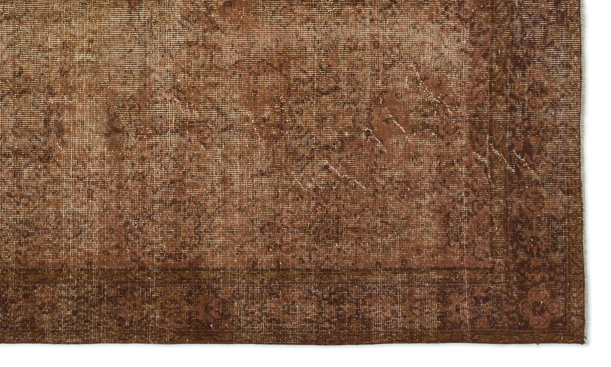 Distressed brown rug with a faded traditional medallion pattern and a wide, ornate border.