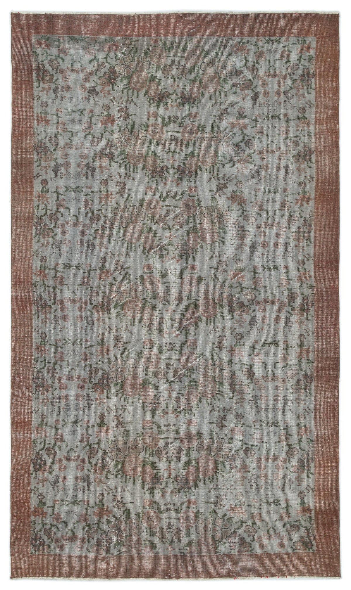 Distressed grey rug with a faded floral pattern and a wide terracotta border.