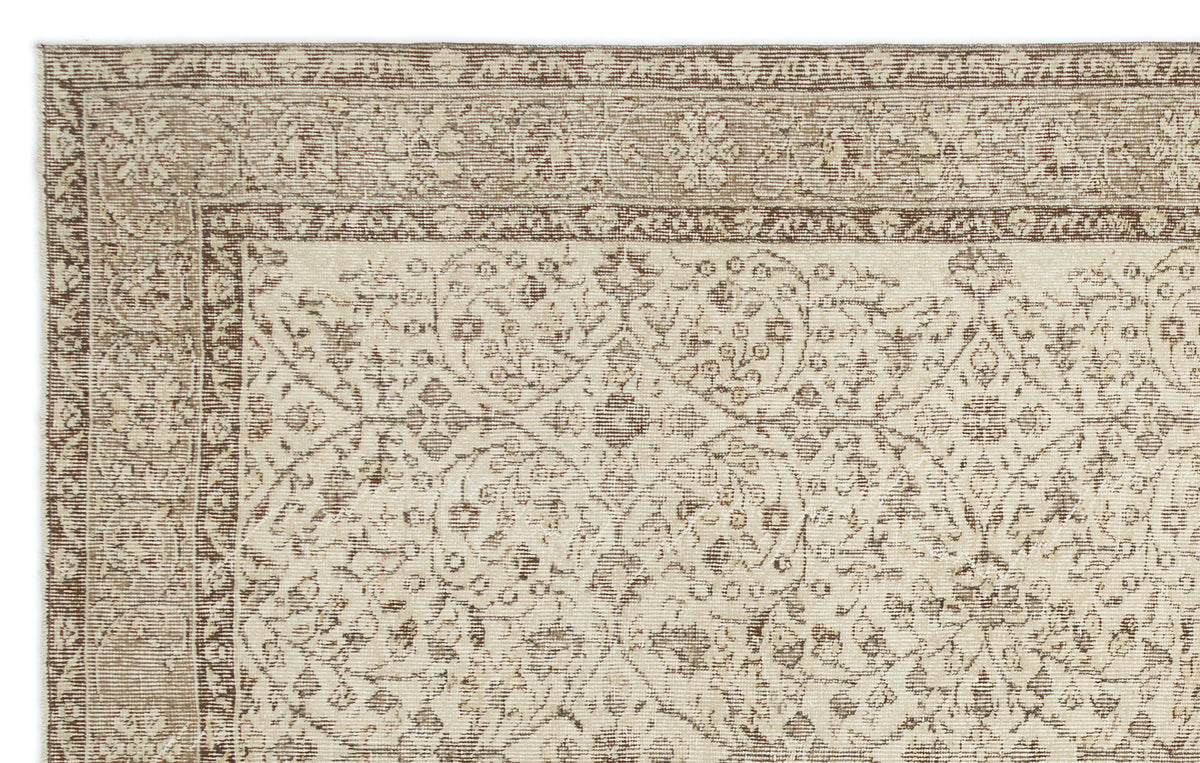 Beige and brown traditional rug with a distressed floral medallion pattern and a detailed border.