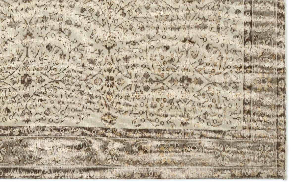 Beige and brown rug with a distressed traditional floral medallion pattern and a wide decorative border.