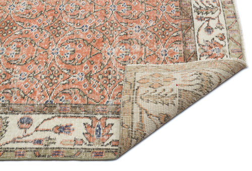 Load image 1 in gallery view. Terracotta and cream traditional rug with a floral medallion pattern and a folded corner showing the woven backing.
