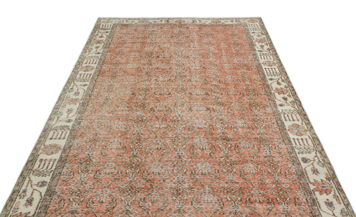 Terracotta and beige traditional rug with an all-over floral pattern and a wide decorative border.