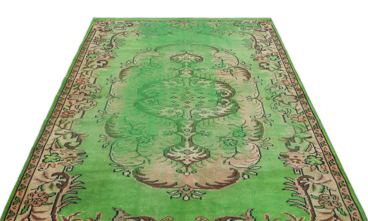 Bright green vintage-style rug with a central floral medallion and ornate border in muted brown and cream tones.