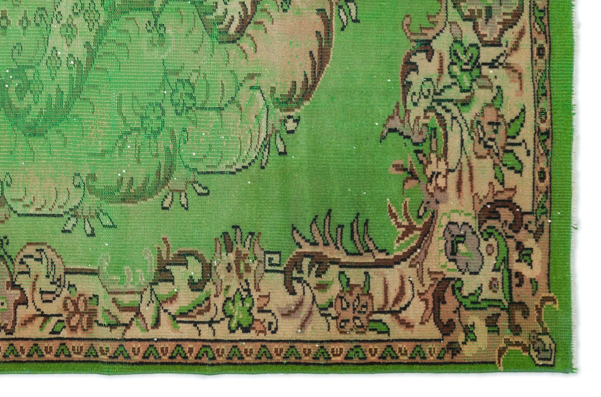 Bright green rug with a tan border featuring intricate floral and vine motifs in brown and black.