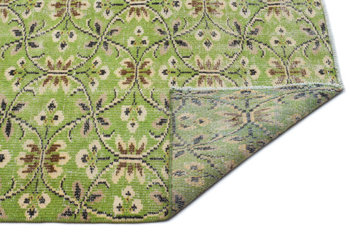 Load image 1 in gallery view. Lime green rug with a brown and cream floral trellis pattern, shown with a corner folded over on a white background.