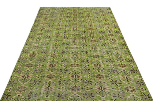 Load image 1 in gallery view. Sage green vintage-style rug with a repeating brown and cream floral medallion pattern on a white background.