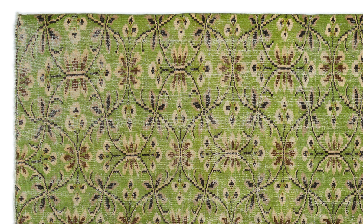 Bright green rug with a repeating brown and beige floral lattice pattern and a distressed finish.