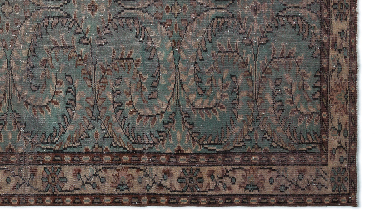 Teal and brown vintage-style rug with a distressed paisley pattern and a geometric border.