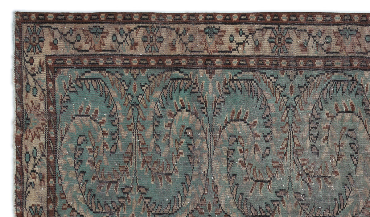 Teal and brown traditional rug with a repeating paisley-style floral pattern and a detailed geometric border.