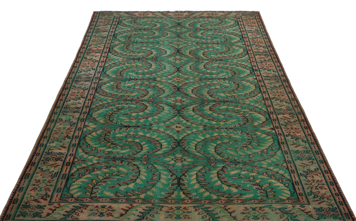 Emerald green and brown vintage-style rug with a repeating swirling leaf pattern and a decorative border.