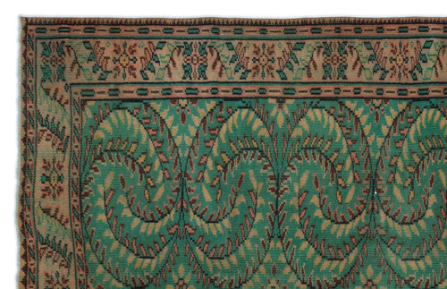 Load image 1 in gallery view. Green and tan vintage-style rug with a repeating paisley-inspired leaf pattern and a decorative floral border.