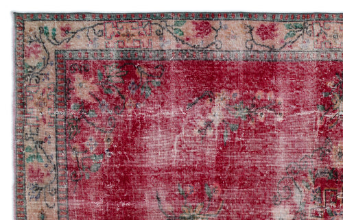 Load image 1 in gallery view. Distressed red rug with a floral border in cream, green, and black, featuring a faded, vintage-style woven texture.