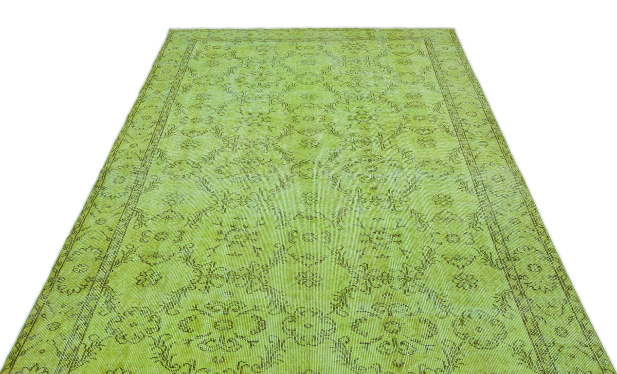 Lime green vintage-style rug with a distressed dark brown floral medallion pattern and a decorative border.