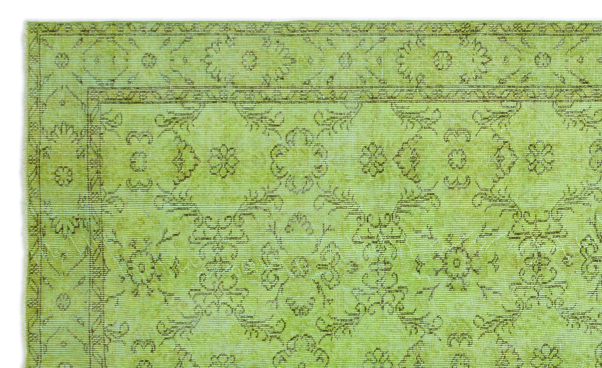 Chartreuse rug with a distressed brown floral medallion pattern and a decorative border.