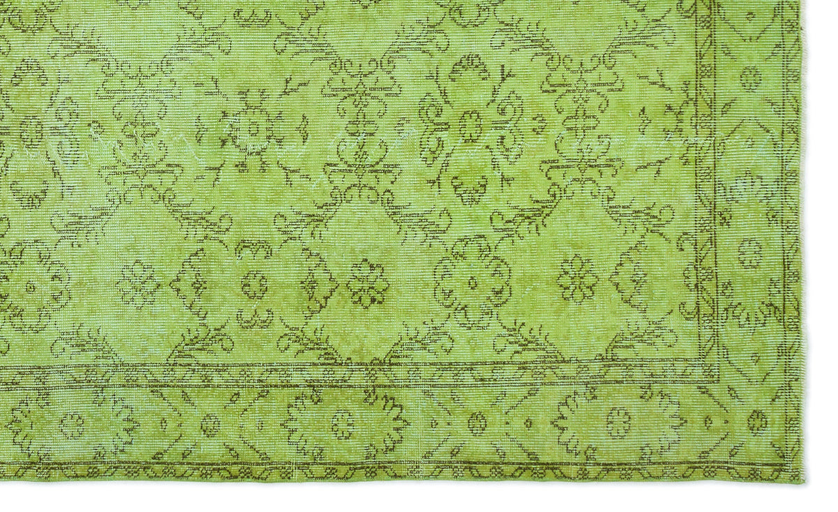 Chartreuse rug with a distressed brown floral medallion pattern and a decorative border.