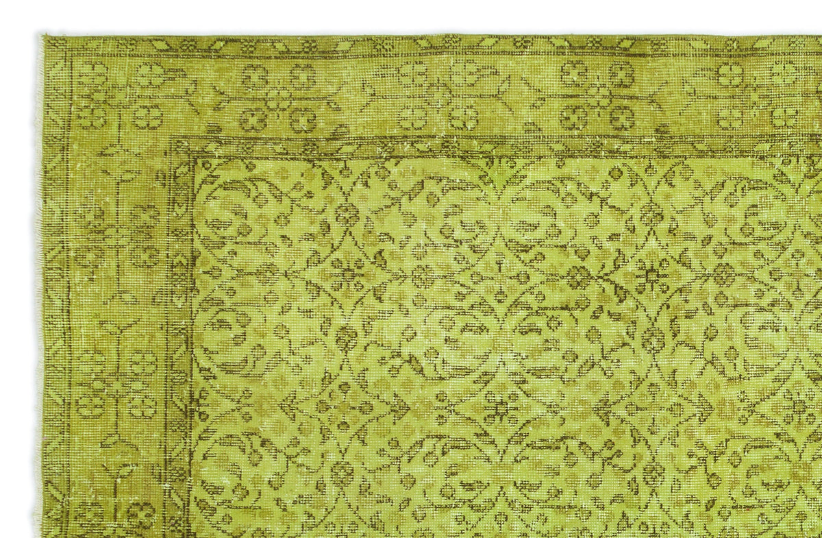 Chartreuse and olive green rug with a distressed traditional floral medallion pattern and a detailed border.