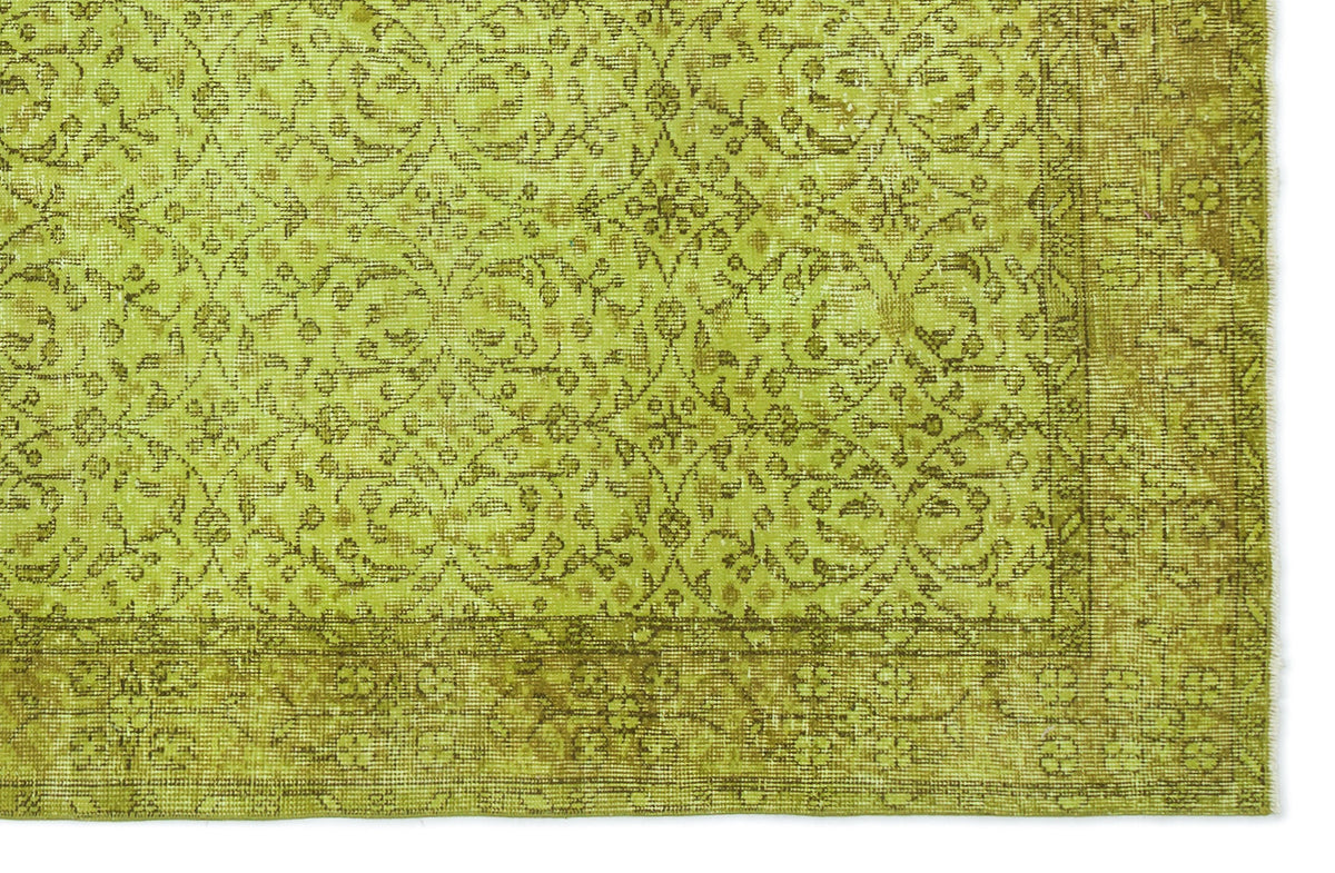 Chartreuse and olive green vintage-style rug with a distressed floral medallion pattern and a wide decorative border.