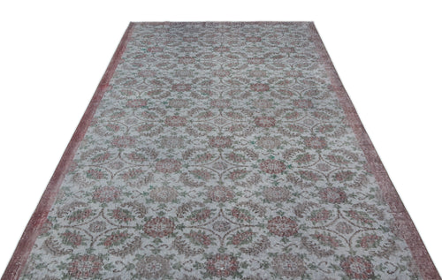 Load image 1 in gallery view. Distressed grey rug with a repeating floral medallion pattern in muted red and green, isolated on a white background.