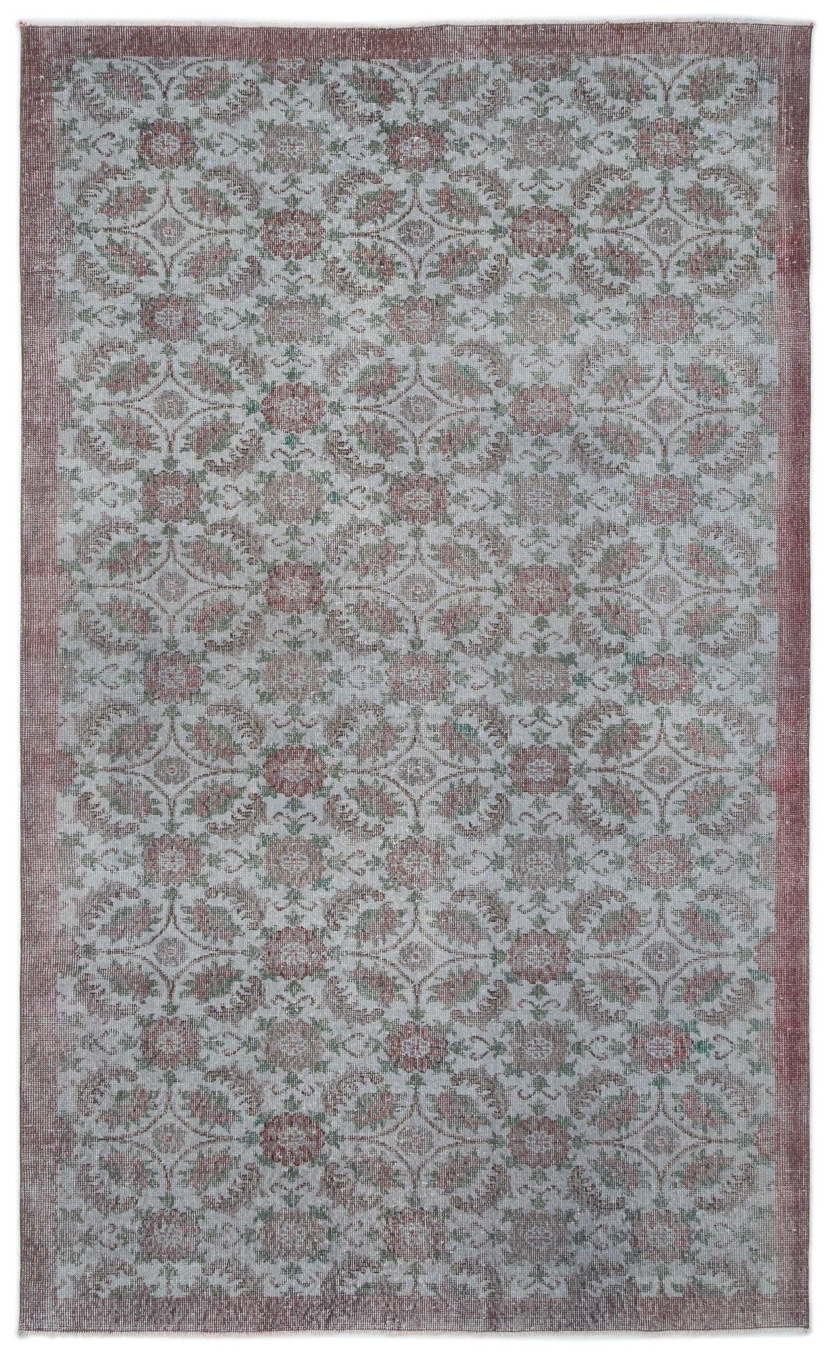 Distressed grey rug with a repeating floral medallion pattern in muted red and green, featuring a solid red border.