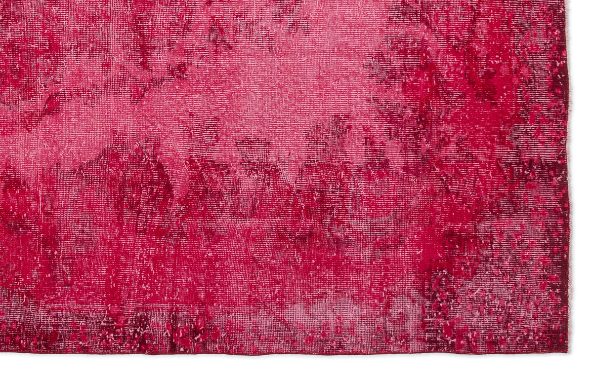 Magenta and deep crimson rug with a distressed, overdyed texture and subtle abstract pattern.
