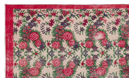 Load image 1 in gallery view. Beige rug with a red border and a repeating floral pattern in shades of pink, green, and dark blue.