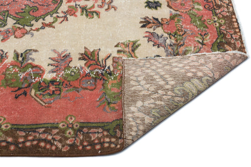 Load image 1 in gallery view. Distressed beige rug with a floral medallion pattern in coral, green, and brown, showing the woven backing.