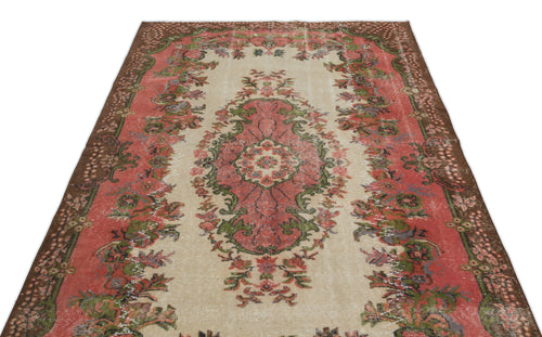 Load image 1 in gallery view. Distressed vintage-style rug with a central floral medallion in coral, green, and cream on a brown border.