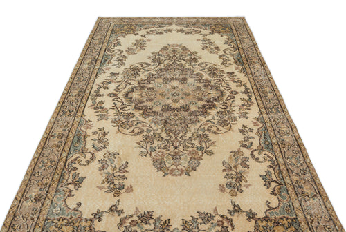 Load image 1 in gallery view. Beige traditional rug with a central floral medallion and intricate border in muted brown, blue, and cream tones.