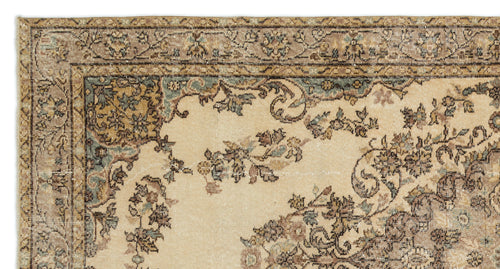 Load image 1 in gallery view. Beige traditional rug with a distressed floral border and central medallion pattern in muted blue, brown, and tan.